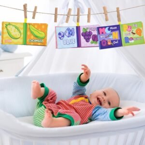 Happy baby playing with hanging crinkle cloth books in a crib