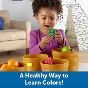 Toddler girl sorting green broccoli into a basket for fine motor skills