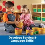 Two children playing market with color sorting baskets and toy food