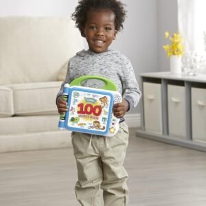A happy young boy holding the LeapFrog 100 Words Book, demonstrating the portable design and easy-to-grip green handle for toddler-friendly learning.