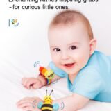 Happy baby during tummy time wearing colorful caterpillar and bee wrist rattles that make enchanting sounds to encourage grabbing and movement.